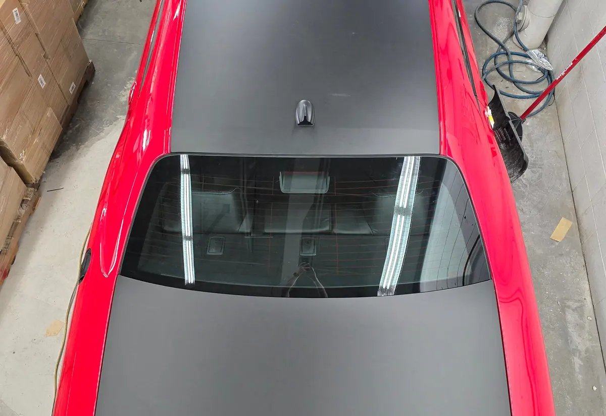 Satin grey colour change film laid over the factory red paint of a car roof