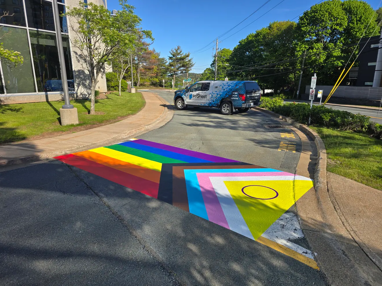 Progress Pride crosswalk pavement graphics installed on a Halifax campus road